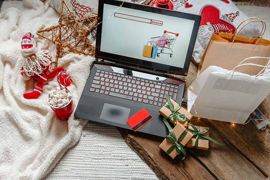 Holiday-themed scene with a laptop, gift boxes, and festive decorations.